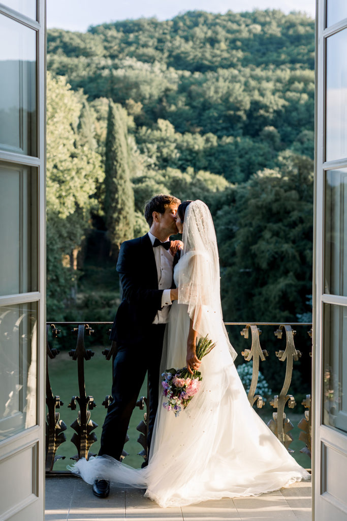 Bride and groom are kissing on the balcony 