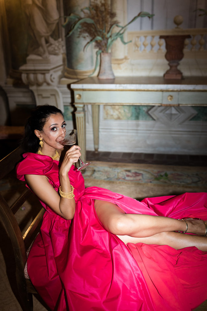 Bride drinking cocktail in a pink dress